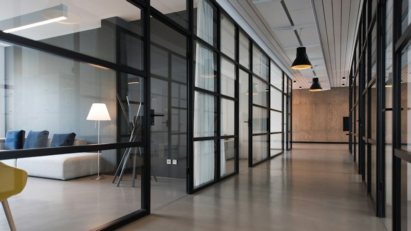 Modern office hallway between glass doors